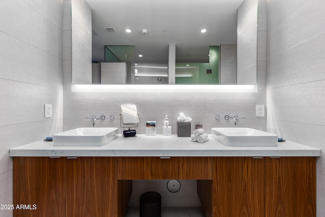 bathroom featuring vanity and tile walls