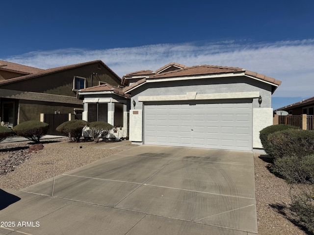 view of front of property featuring a garage, concrete driveway, stucco siding, and a tile roof