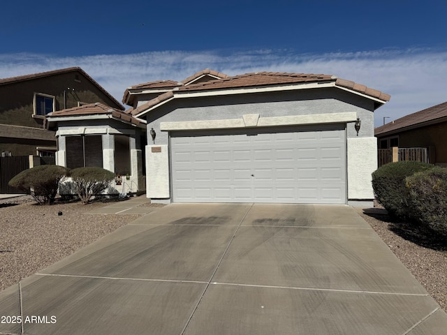 view of front facade with stucco siding, an attached garage, driveway, and a tile roof