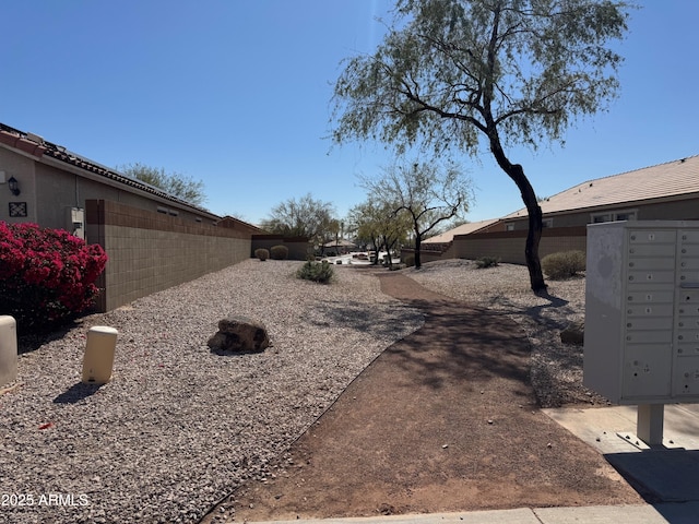 view of yard with mail area and fence