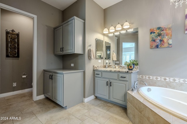 bathroom featuring tile patterned flooring, vanity, a relaxing tiled tub, and toilet