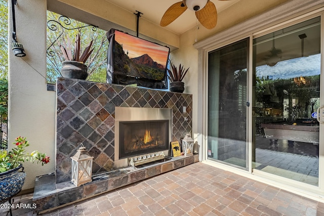 view of patio / terrace with ceiling fan and a tiled fireplace