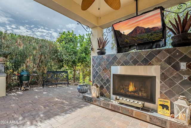 view of patio with a tile fireplace, ceiling fan, and grilling area