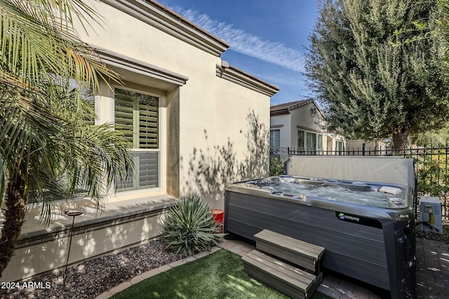 view of home's exterior with a hot tub