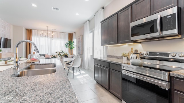 kitchen featuring dark brown cabinetry, visible vents, appliances with stainless steel finishes, and a sink