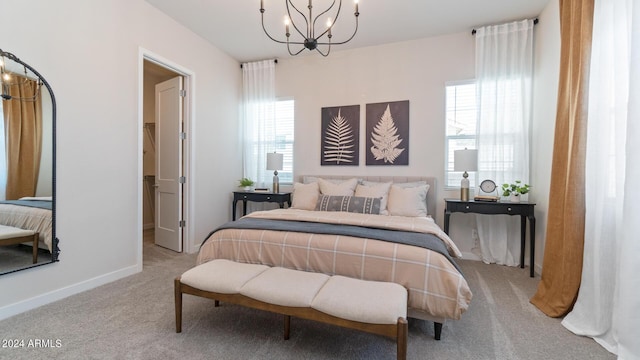 bedroom with a chandelier, carpet flooring, and baseboards