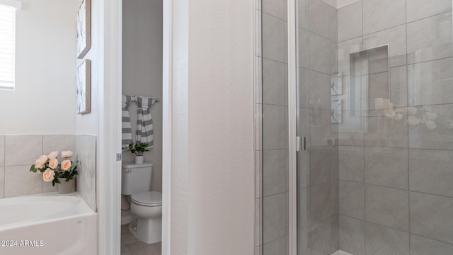 bathroom featuring toilet, a bath, a stall shower, and tile patterned flooring