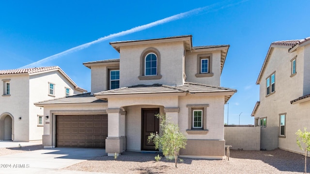 view of front of property featuring fence, driveway, stucco siding, a garage, and a tiled roof