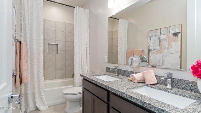 bathroom with double vanity, shower / tub combo, toilet, and a sink