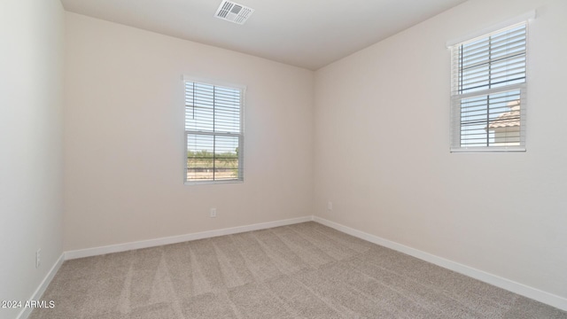 spare room featuring visible vents, baseboards, and carpet