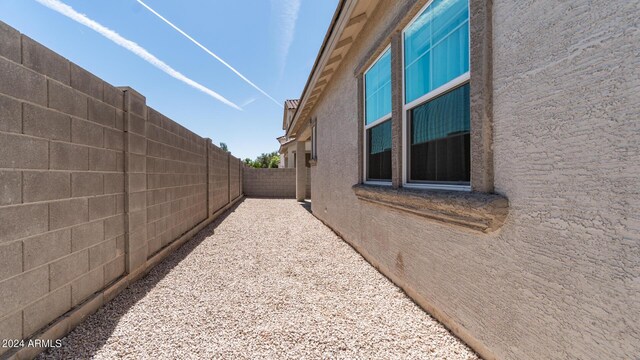 view of side of property with stucco siding and fence