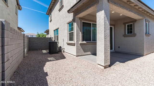 exterior space with a fenced backyard, central air condition unit, stucco siding, and a patio