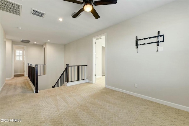 carpeted spare room with ceiling fan