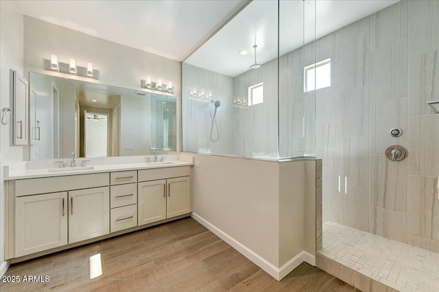 bathroom featuring vanity, tiled shower, and hardwood / wood-style floors