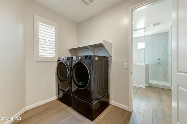 washroom featuring light wood-type flooring and washer and clothes dryer