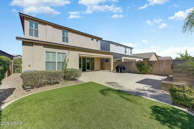 back of property featuring a patio and a lawn