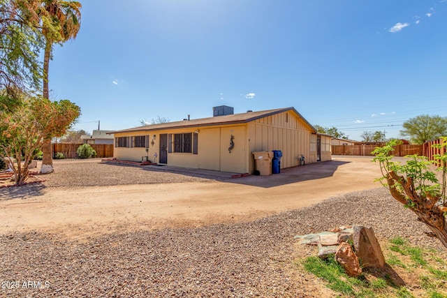 rear view of property with a patio area, board and batten siding, and a fenced backyard