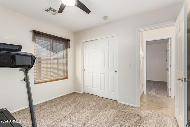 exercise area with ceiling fan and light colored carpet