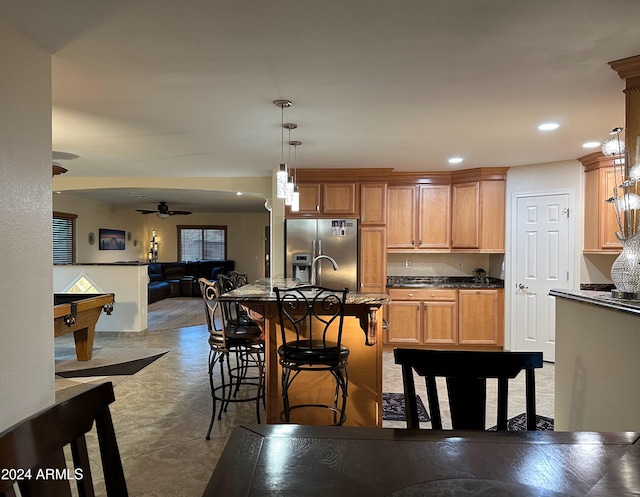 kitchen with pendant lighting, stainless steel fridge, ceiling fan, a kitchen breakfast bar, and pool table