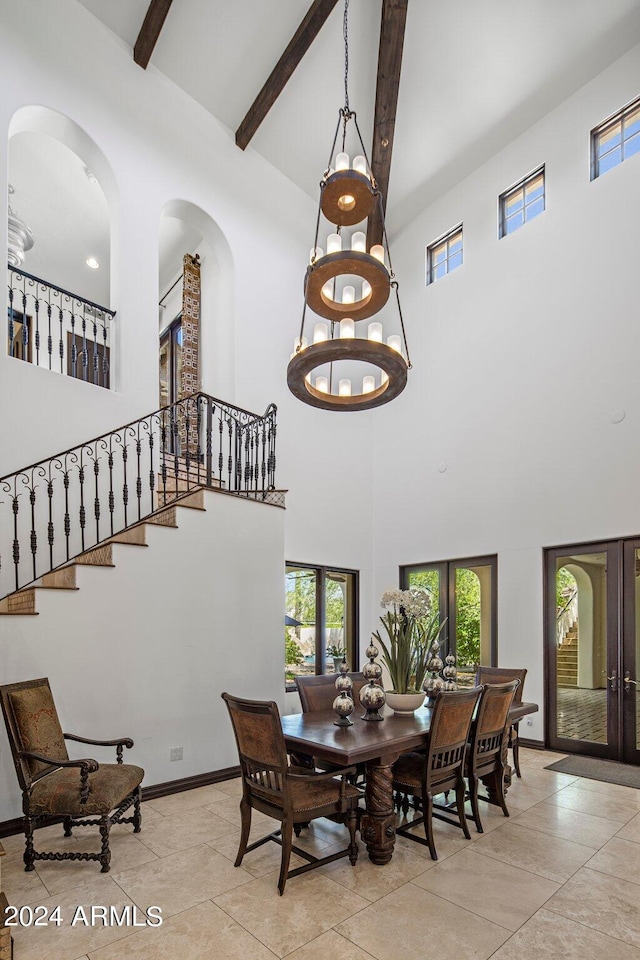 dining room featuring beam ceiling and a high ceiling