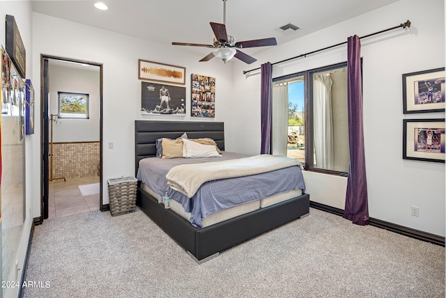 carpeted bedroom with ensuite bath and ceiling fan