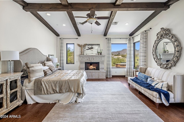 bedroom with multiple windows, dark hardwood / wood-style floors, beam ceiling, and ceiling fan