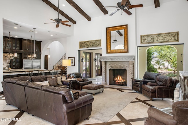 living room featuring a wealth of natural light, beamed ceiling, a high end fireplace, and high vaulted ceiling