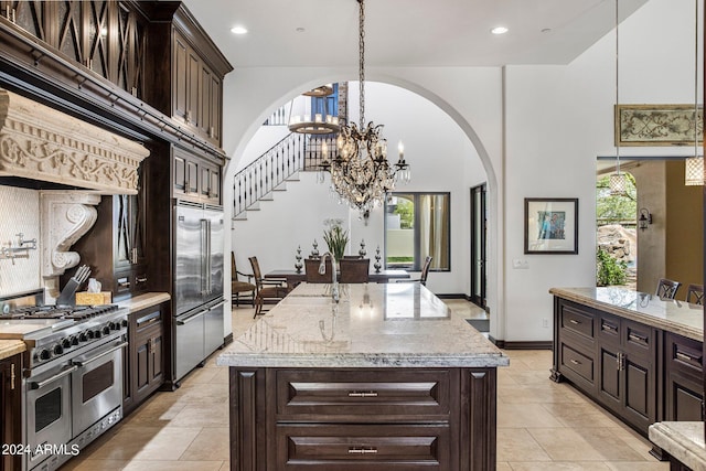 kitchen featuring a center island with sink, dark brown cabinets, and premium appliances