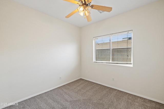 spare room featuring baseboards, ceiling fan, and carpet