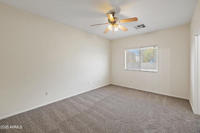 carpeted empty room with visible vents, baseboards, and ceiling fan