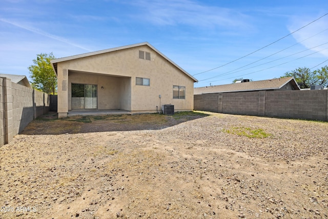 back of house featuring a fenced backyard, a patio area, stucco siding, and central AC unit