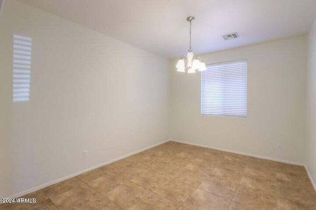 unfurnished room featuring an inviting chandelier