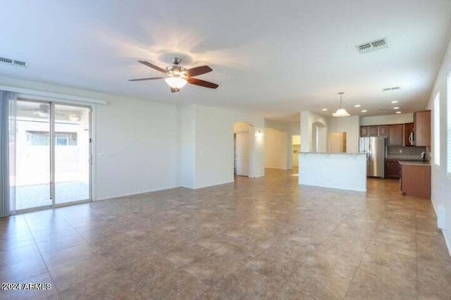 unfurnished living room featuring ceiling fan