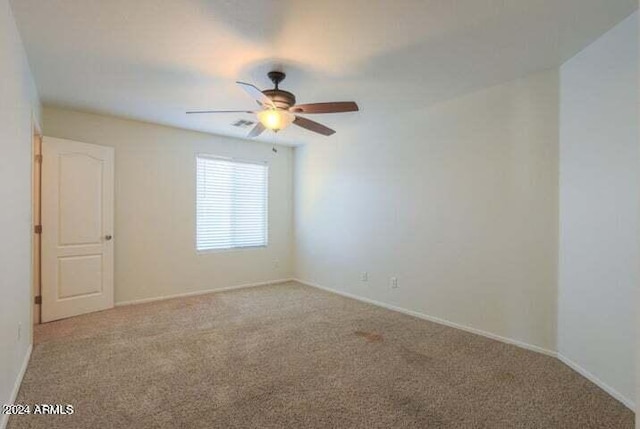 carpeted spare room featuring ceiling fan