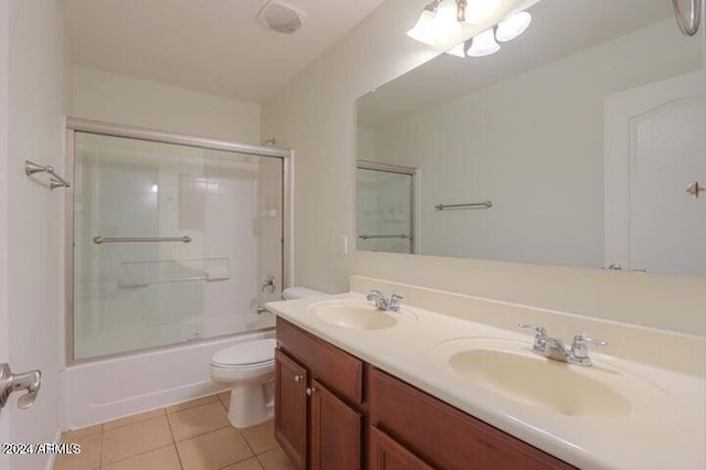 full bathroom with toilet, vanity, shower / bath combination with glass door, and tile patterned flooring