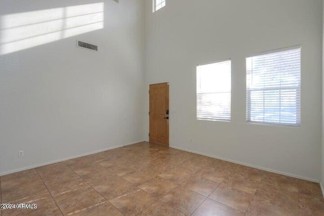 empty room with a towering ceiling and plenty of natural light