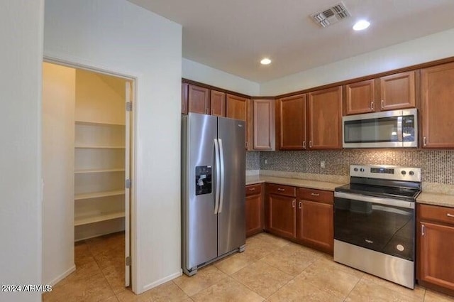 kitchen featuring stainless steel appliances, tasteful backsplash, and light tile patterned flooring