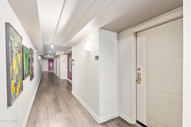 hallway with light wood-style floors and baseboards