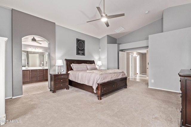 bedroom with light carpet, baseboards, visible vents, and ensuite bathroom