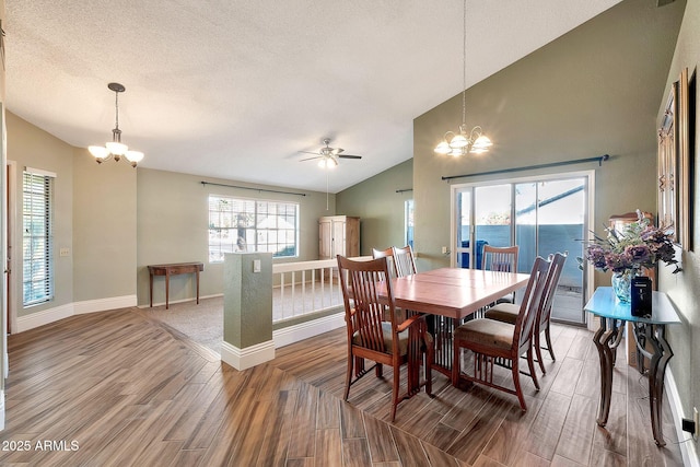 dining space featuring hardwood / wood-style floors, vaulted ceiling, a water view, a textured ceiling, and ceiling fan with notable chandelier