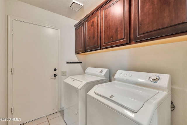 laundry area featuring cabinets, separate washer and dryer, and light tile patterned floors