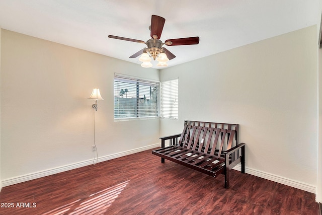 living area featuring ceiling fan and dark wood-type flooring