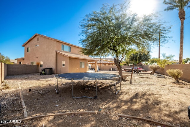 rear view of house featuring a trampoline