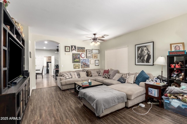 living room featuring ceiling fan and dark hardwood / wood-style floors