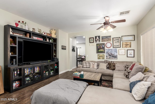 living room featuring ceiling fan and dark wood-type flooring