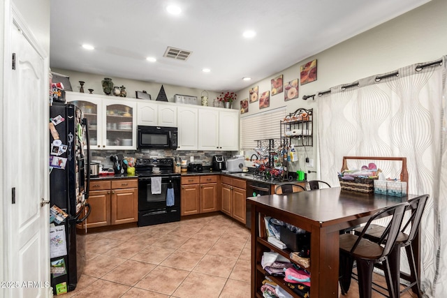 kitchen featuring white cabinets, light tile patterned floors, black appliances, and tasteful backsplash