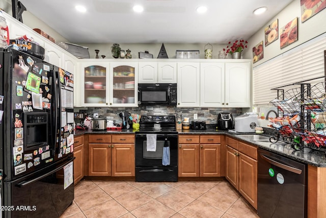 kitchen with white cabinets, black appliances, dark stone counters, decorative backsplash, and light tile patterned flooring