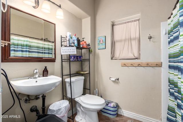 bathroom featuring sink, toilet, walk in shower, and tile patterned flooring