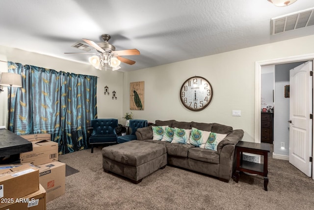 living room with carpet, ceiling fan, and a textured ceiling