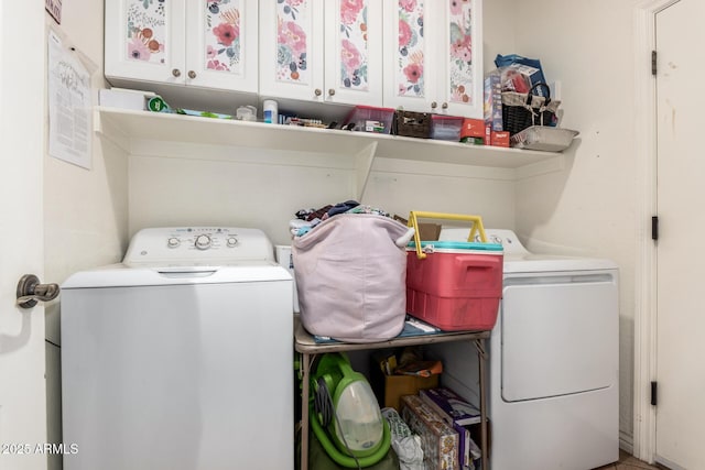 laundry room with washing machine and dryer and cabinets